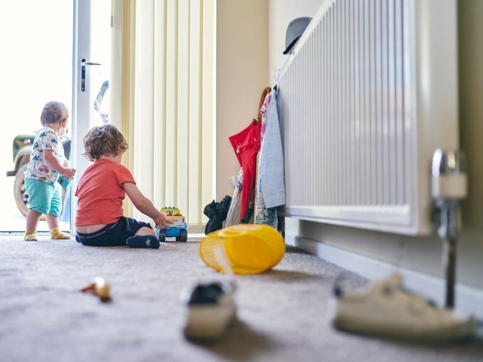 Children playing near a radiator.