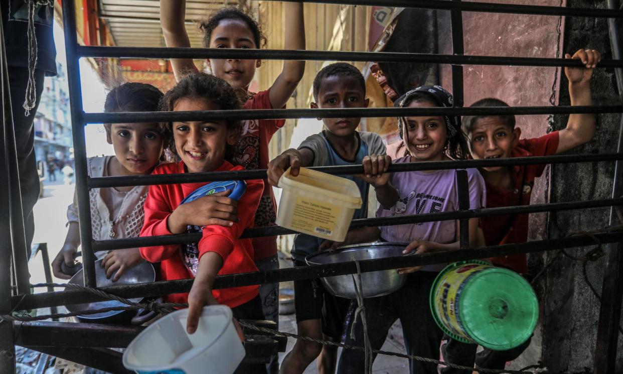 <span>Children queuing for food aid in Rafah: the UN says 1.1 million people are expected to live with catastrophic hunger within three months.</span><span>Photograph: Anadolu/Getty Images</span>