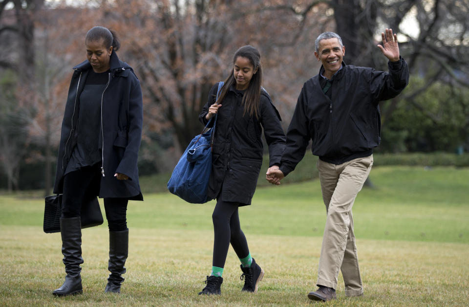 President Barack Obama -- with first lady Michelle Obama, and their daughter Malia -- waves as they arrive at the White House in Washington, Sunday, Jan. 4, 2015, from a family vacation in Hawaii.