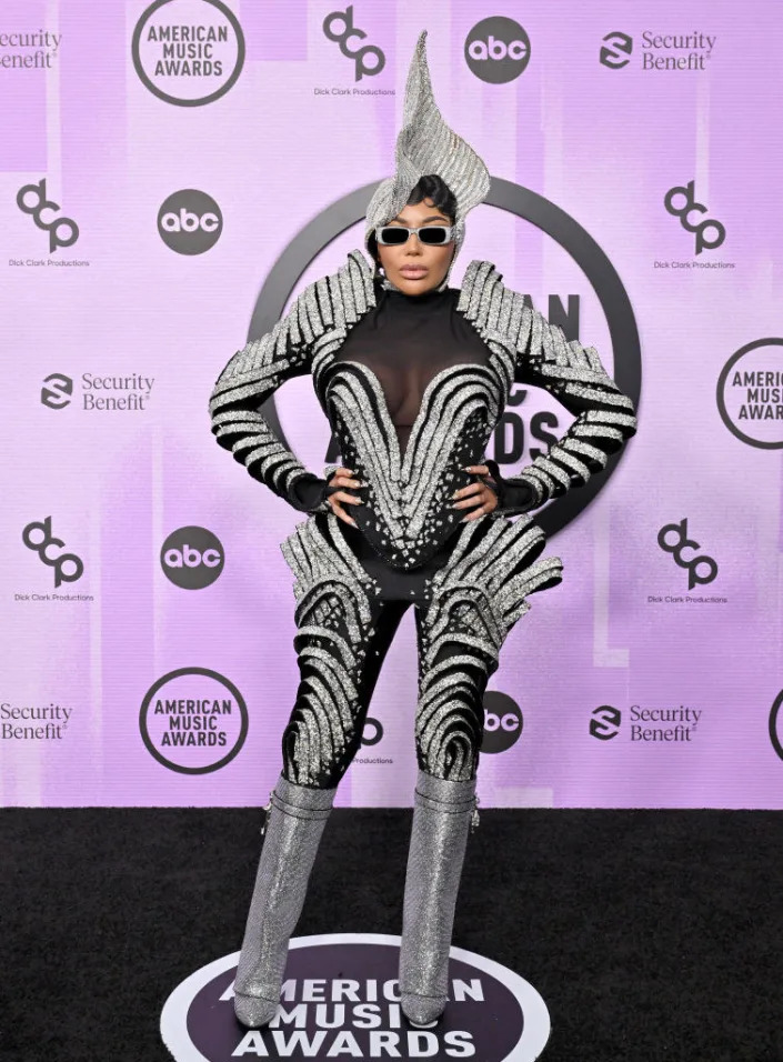 Dencia in a futuristic chrome catsuit and headpiece