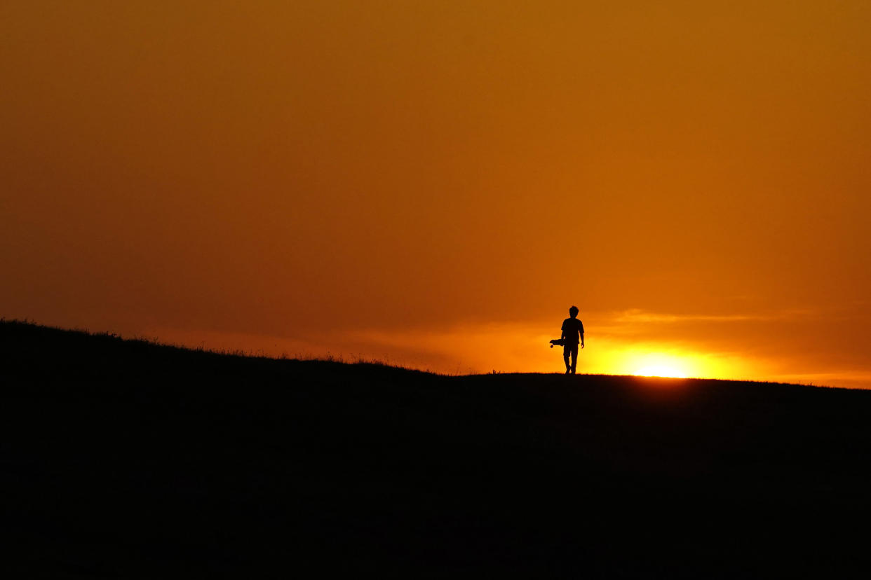 Person walking at sunset. (Eric Gay)