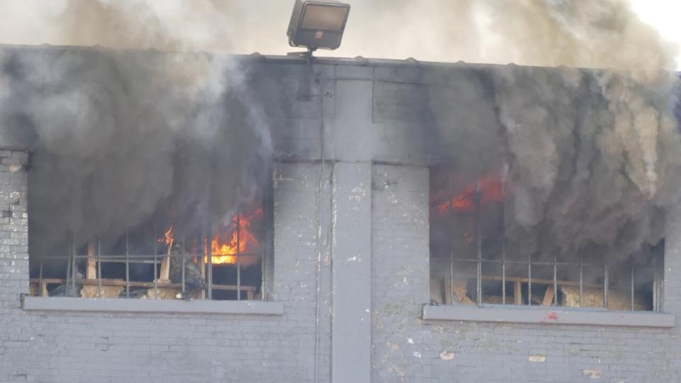 Fire and smoke are coming out of the concrete building.