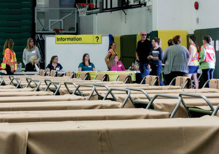 Volunteers listen to emergency services managers as they prepare for wildfire evacuees to arrive and start occupying the 170 cots set up in the Northen Sports Centre at the University of Northern BC in Prince George, British Columbia, Canada July 10, 2017. REUTERS/Chuck Nisbett