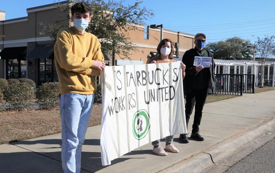 From left, Ethan Bischof, 17, Breanna Stamper, 22, and William, who would not say his last name, hold signs supporting Starbucks workers.