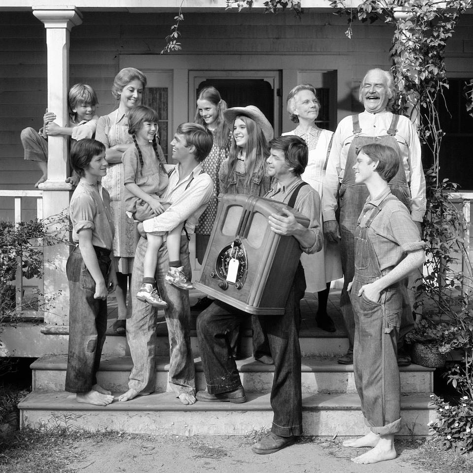 This 1974 photo provided by CBS shows, from left, David Harper, as Jim-Bob Walton; Eric Scott, as Ben Walton; Michael Learned, as Olivia Walton; Kami Cotler, as Elizabeth Walton; Richard Thomas, as John Boy Walton; Mary McDonough, as Erin Walton; Judy Norton, as Mary Ellen Walton; Ralph Waite, as John Walton; Ellen Corby, as Ester “Grandma” Walton; Will Geer, as Zeb “Grandpa” Walton; Jon Walmsley, as Jason Walton, in the television show The Waltons. (CBS Photo Archive via AP)