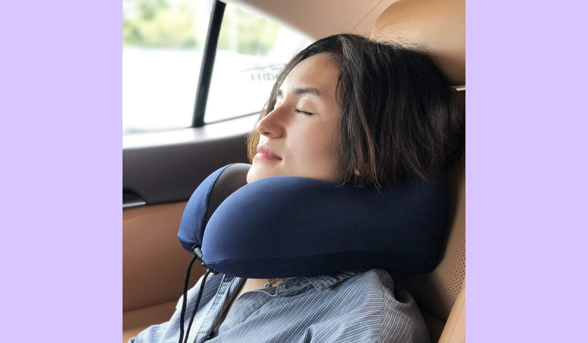 someone wearing the blue travel neck pillow