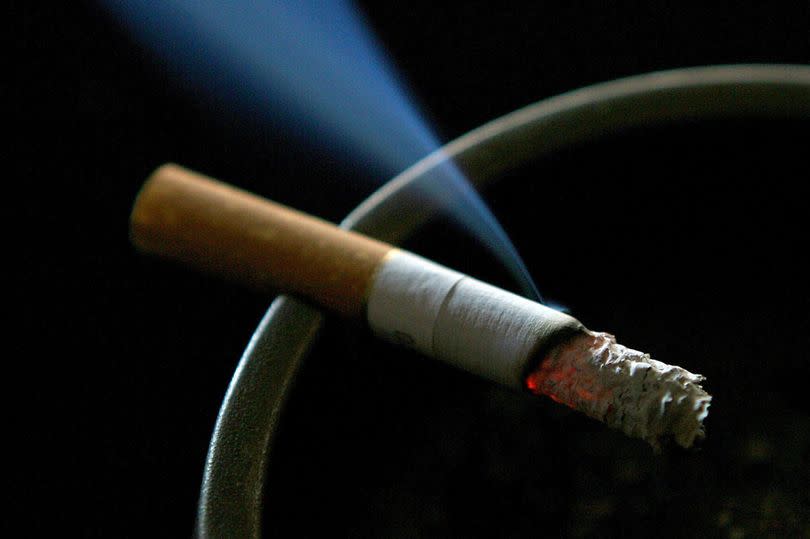 A file photo of a cigarette burning on an ashtray