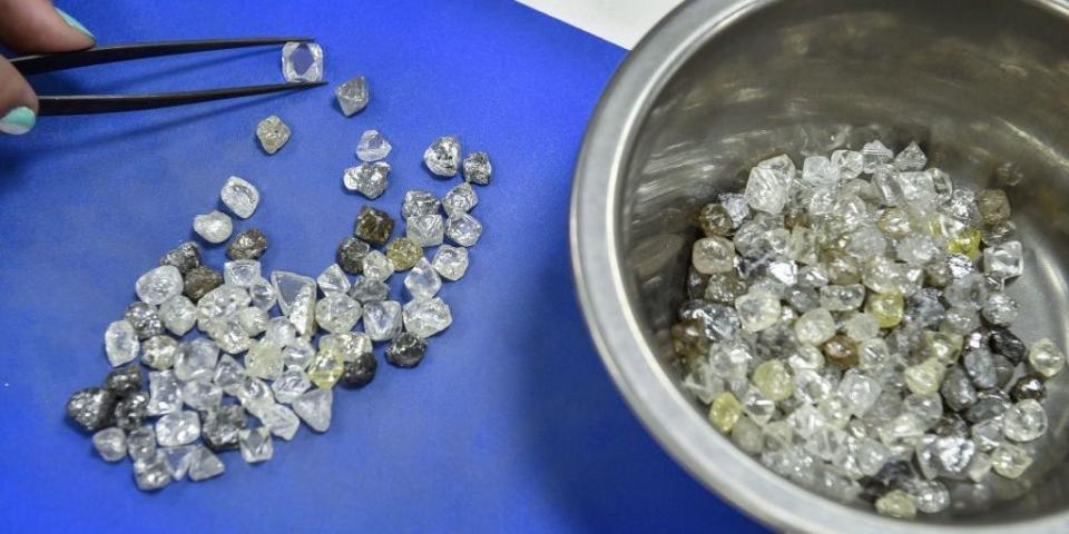 Ein Mitarbeiter inspiziert Rohdiamanten im Alrosa Diamond Sorting Center in der russischen Stadt Mirny (Foto aus 2019). - Copyright: ALEXANDER NEMENOV/AFP via Getty Images