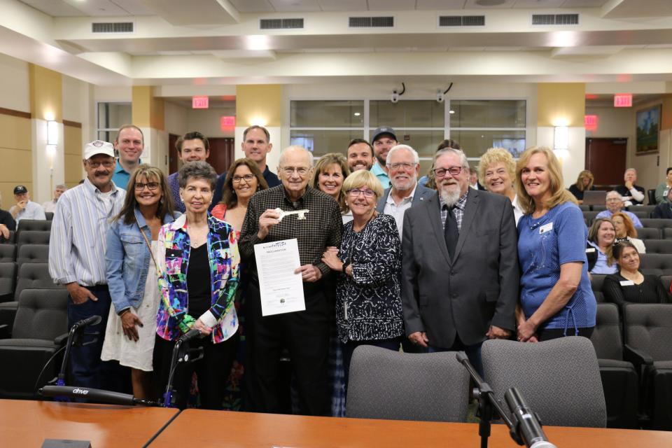 Gene Matthews, front row, third from left, shows off the key to the city and proclamation designating April 11, 2023 as Gene Matthews Day, Tuesday morning at the North Port City Commission meeting. The Boys & Girls Clubs of Sarasota and DeSoto Counties later unveiled plans for a new $4.5 million, 14,000-square-foot club to replace the existing facility that was damaged by Hurricane Ian.