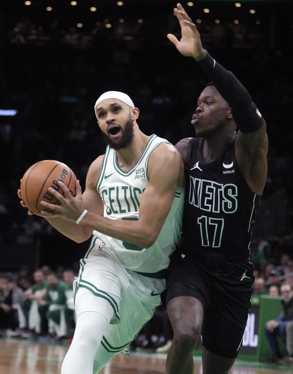 Boston Celtics guard Derrick White (9) drives to the basket against Brooklyn Nets guard Dennis Schroder (17) during the first half of an NBA basketball game, Wednesday, Feb. 14, 2024, in Boston. (AP Photo/Charles Krupa)