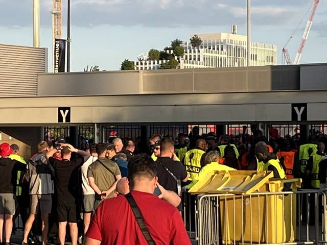 Fans wait outside the gates to enter the stadium