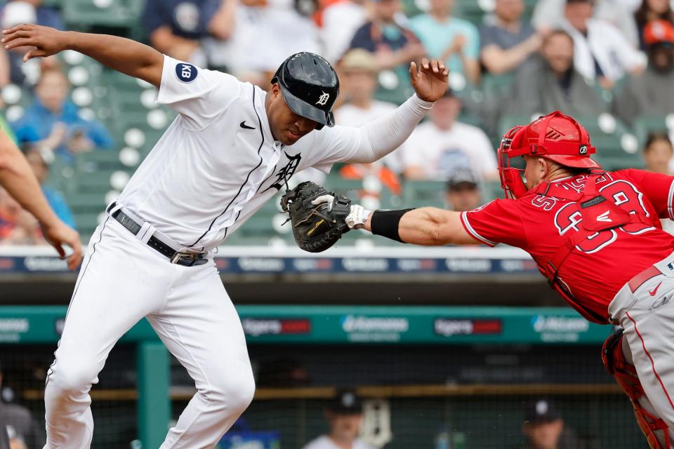 Tigers second baseman Jonathan Schoop avoids the first tag by Angels catcher Max Stassi in the third inning Aug. 20, 2022 at Comerica Park.