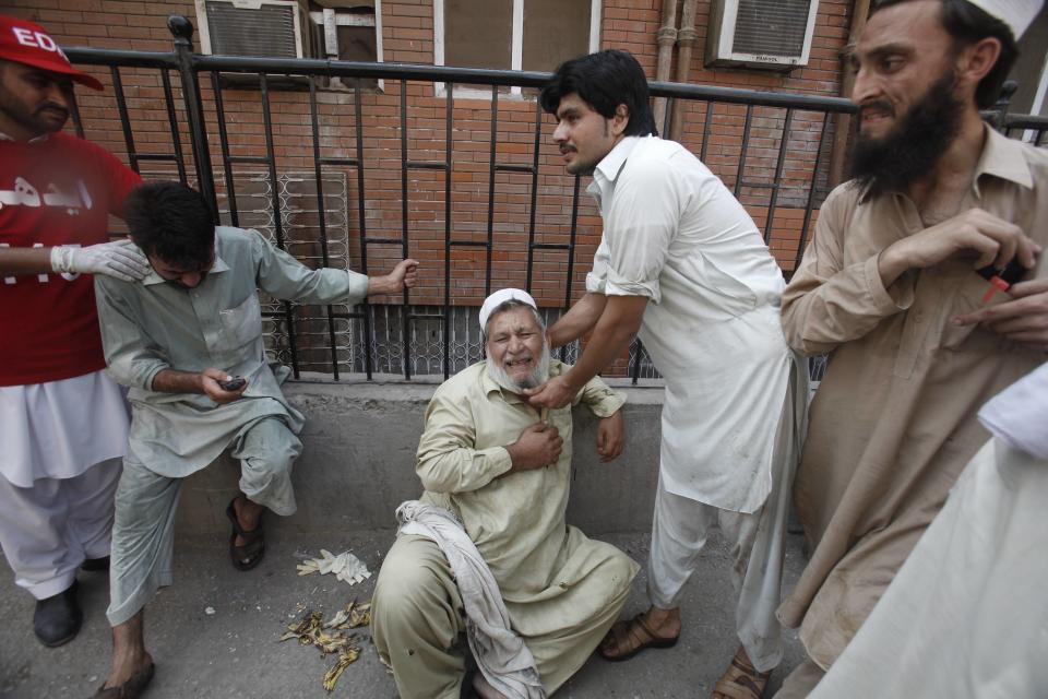 Man cries over death of his son, who was killed in a bomb blast, at a hospital in Peshawar