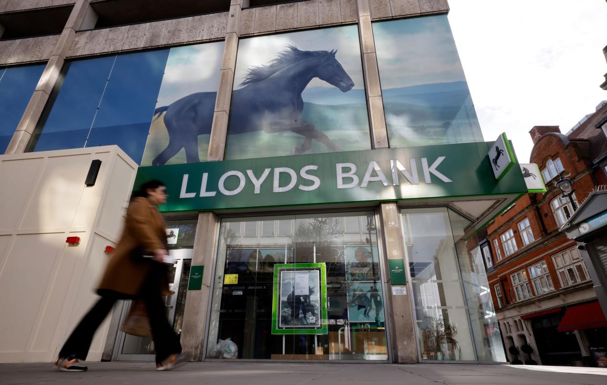 A pedestrian walks past a temporarily closed-down branch of a Lloyds Bank in London on February 24, 2021. - Britain's Lloyds Banking Group on Wednesday reported a slump in 2020 profit due to 