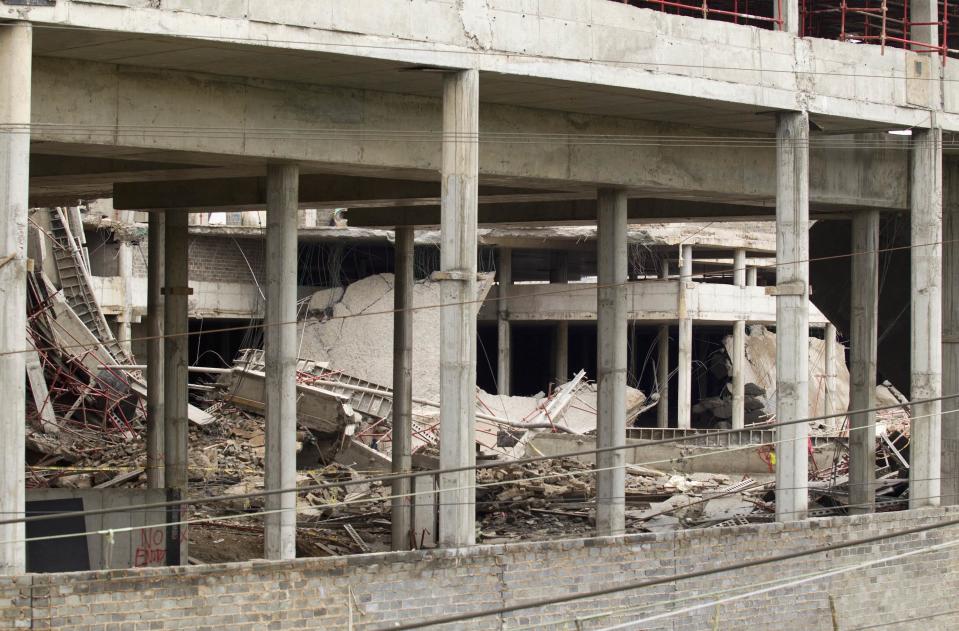 A view of a three-storey building that collapsed is seen in the South African town of Tongaat, about 45 km (28 miles) north of Durban, November 20, 2013. Rescue workers with sniffer dogs picked through rubble in search of survivors on Wednesday after a soccer pitch-sized section of a half-built mall collapsed, killing at least one and injuring dozens. It was not immediately clear how many people might be still trapped in the wreckage after the three-storey building collapsed on Tuesday afternoon. Apart from one confirmed death, 29 people, two of them in critical condition, were rushed to nearby hospitals, which initiated full-scale disaster plans, health officials said. REUTERS/Rogan Ward (SOUTH AFRICA - Tags: DISASTER)