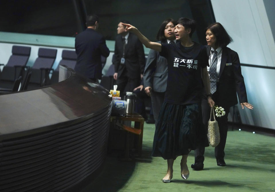 Pro-democracy lawmaker Claudia Mo, front, is escorted to leave as she protested while Hong Kong Chief Executive Carrie Lam arrives at chamber of the Legislative Council in Hong Kong, on Thursday, Oct. 17, 2019. (AP Photo/Vincent Yu)