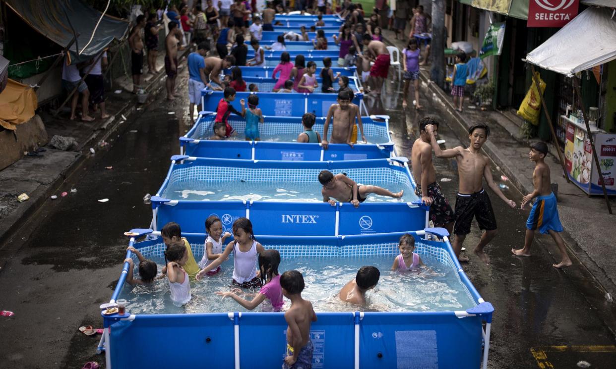 <span>Children play in portable pools, a project from the local government, to beat the heat in Manila, Philippines.</span><span>Photograph: Noel Celis/AFP/Getty Images</span>