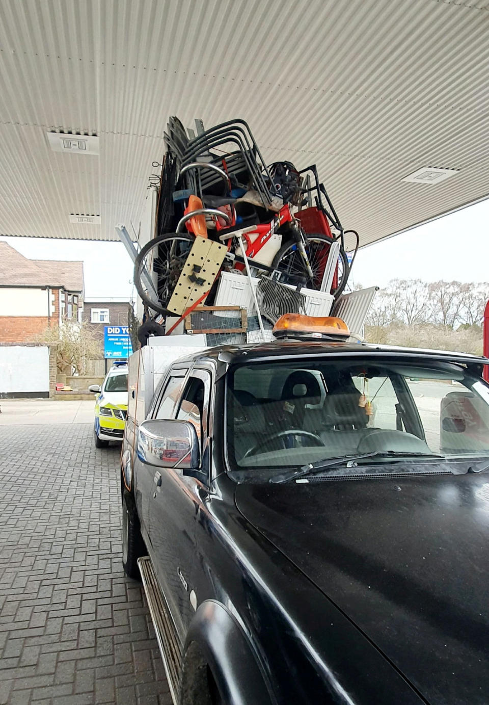 Police were left stunned after pulling over this dangerously overloaded pick-up truck which was piled high with a mountain of rubbish held together by pieces of rope. (SWNS)