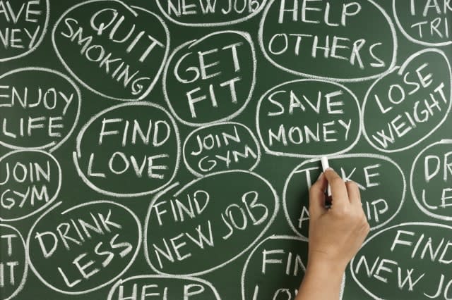 woman hand writing new year's resolutions for 2013 on the blackboard