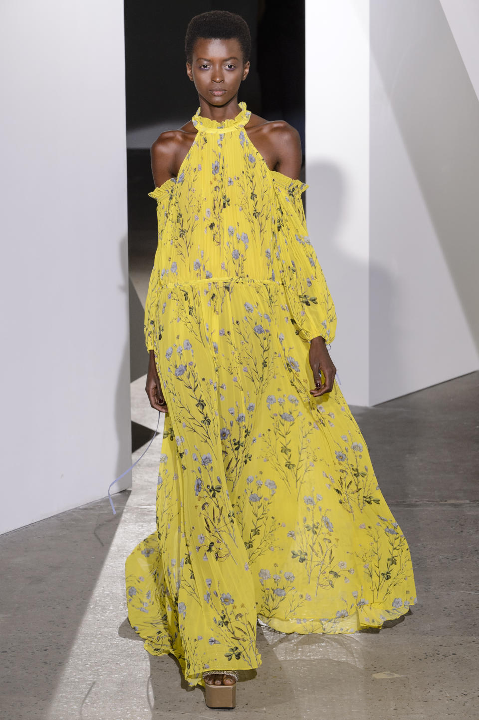 <p><i>Model wears a high-neck, exposed-shoulder, yellow floral dress from the SS18 Self-Portrait collection. (Photo: ImaxTree) </i></p>