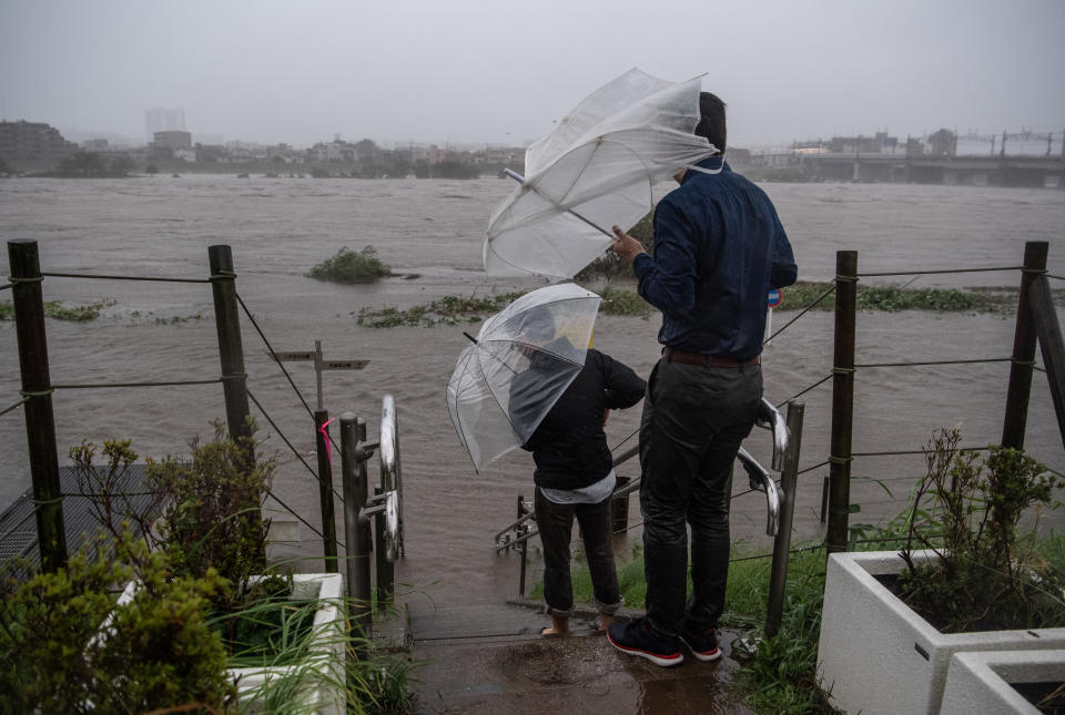 TOKYO, JAPAN - OCTOBER 12: People look at the flooded Tama River during Typhoon Hagibis on October 12, 2019 in Tokyo, Japan. Typhoon Hagibis is the most powerful typhoon to hit Japan this year and has been classed by the Japan Meteorological Agency as a 'violent typhoon' - the highest category on Japans typhoon scale. (Photo by Carl Court/Getty Images)