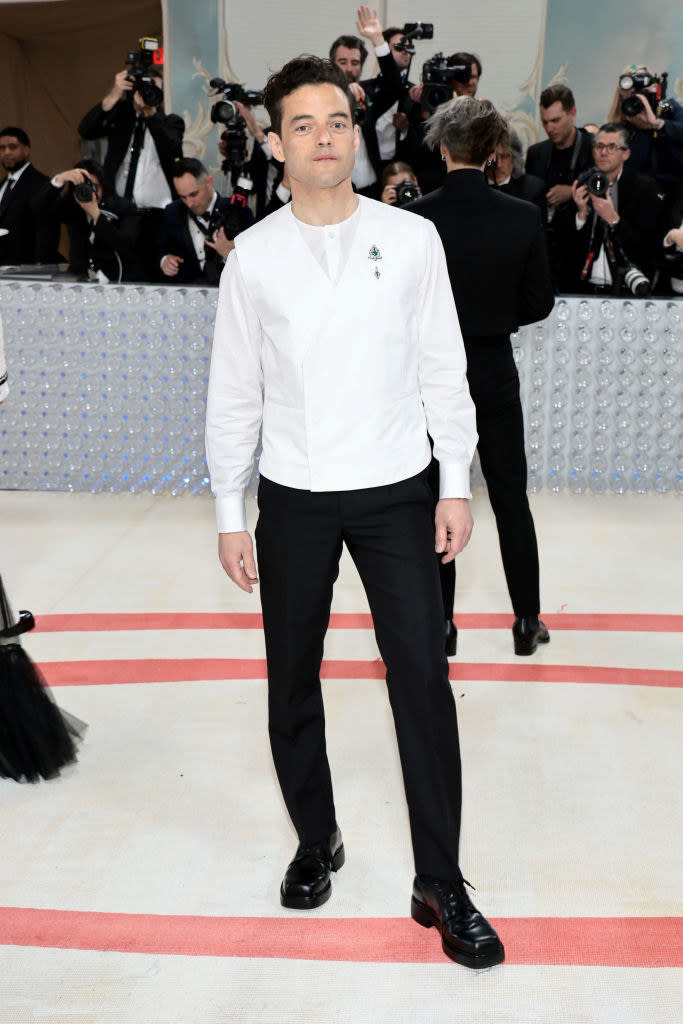 Rami Malek attends The 2023 Met Gala in a white suit coat