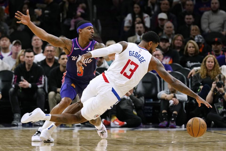 Clippers forward Paul George is fouled by Suns guard Bradley Beal as George dives for the ball on Wednesday in Phoenix.