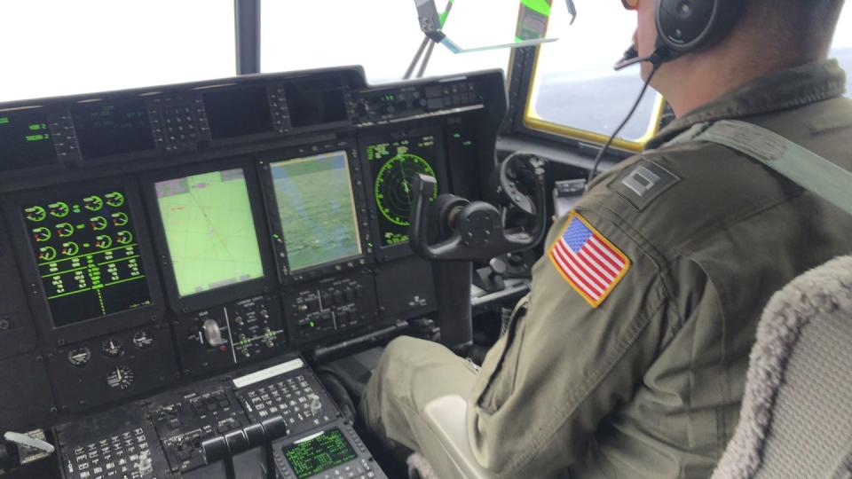 In this image provided by the U.S. Coast Guard, a crew member sits aboard a Coast Guard HC-130 Hercules airplane based at Coast Guard Air Station Elizabeth City, N.C., as it flies about 900 miles East of Cape Cod, Mass., during the search for the 21-foot submersible, Titan, Wednesday, June 21, 2023. (Petty Officer 1st Class Amber Howie/U.S. Coast Guard via AP)