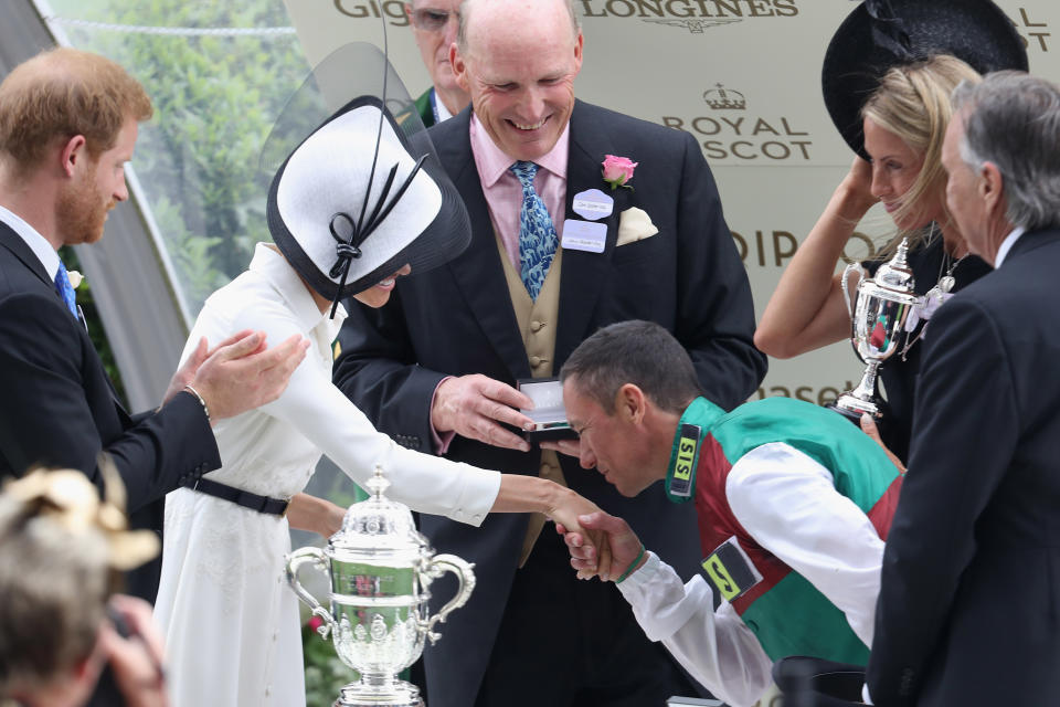 Meghan, Duchess of Sussex receives a kiss from Jockey Frankie Dettori as she and Prince Harry, Duke of Sussex present him with the trophy for winning the St James's Palace Stakes on Without Parole during Royal Ascot Day 1.