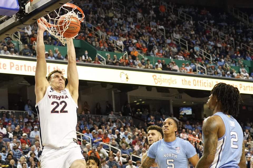 Virginia center Francisco Caffaro (22) dunks as North Carolina forward Armando Bacot (5) and guard Caleb Love (2) watch during the first half of an NCAA college basketball game at the Atlantic Coast Conference Tournament in Greensboro, N.C., Thursday, March 9, 2023. (AP Photo/Chuck Burton)