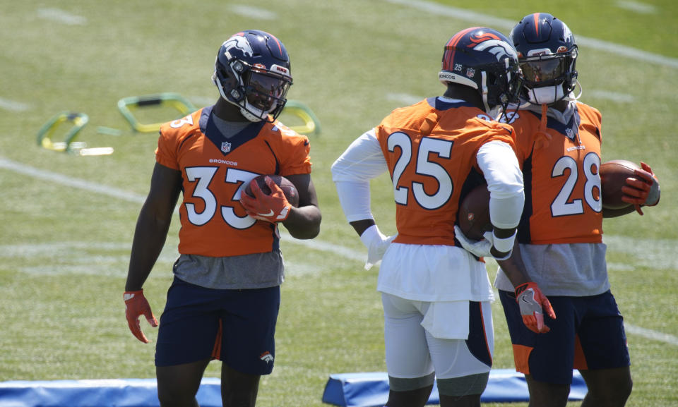 From left, Denver Broncos running backs Javonte Williams, Melvin Gordon and Royce Freeman confer as they takes part in drills during a mandatory minicamp at the NFL team's training headquarters Tuesday, June 15, 2021, in Englewood, Colo. (AP Photo/David Zalubowski)