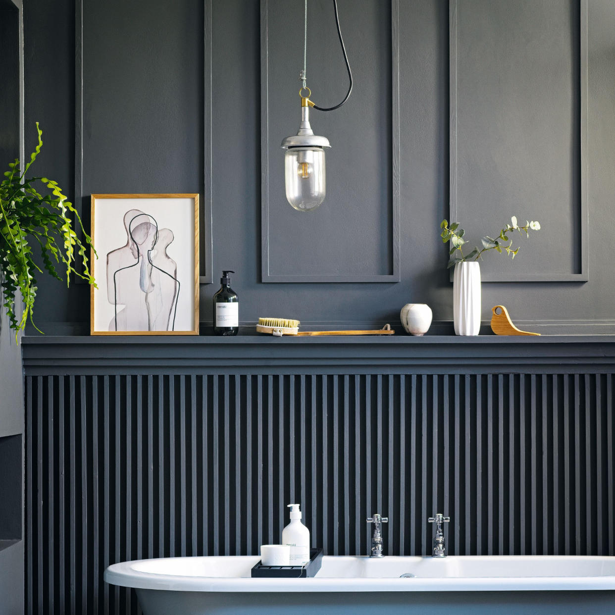  Dark painted bathroom with panel moulding feature wall, blue bathtub 