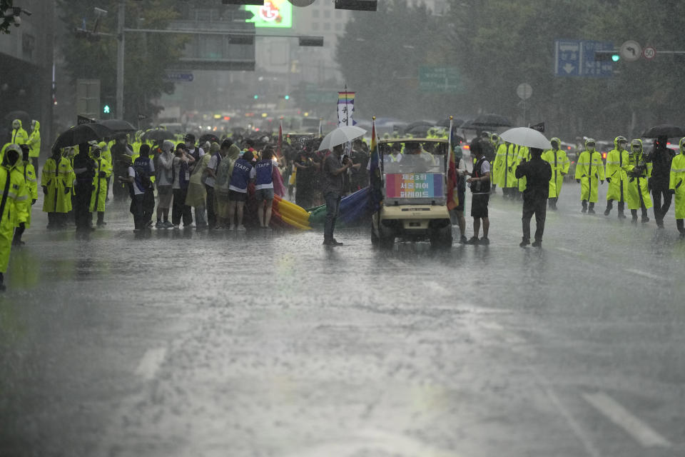 Volunteers carry a huge rainbow flag as police officers guard during a parade as a part of the 23rd Seoul Queer Culture Festival which is held from from July 15 to July 31, in Seoul, South Korea, Saturday, July 16, 2022. Thousands of gay rights supporters celebrated under a heavy police guard in the South Korean capital on Saturday as they marked the city’s first Pride parade in three years after a COVID-19 hiatus. (AP Photo/Lee Jin-man)