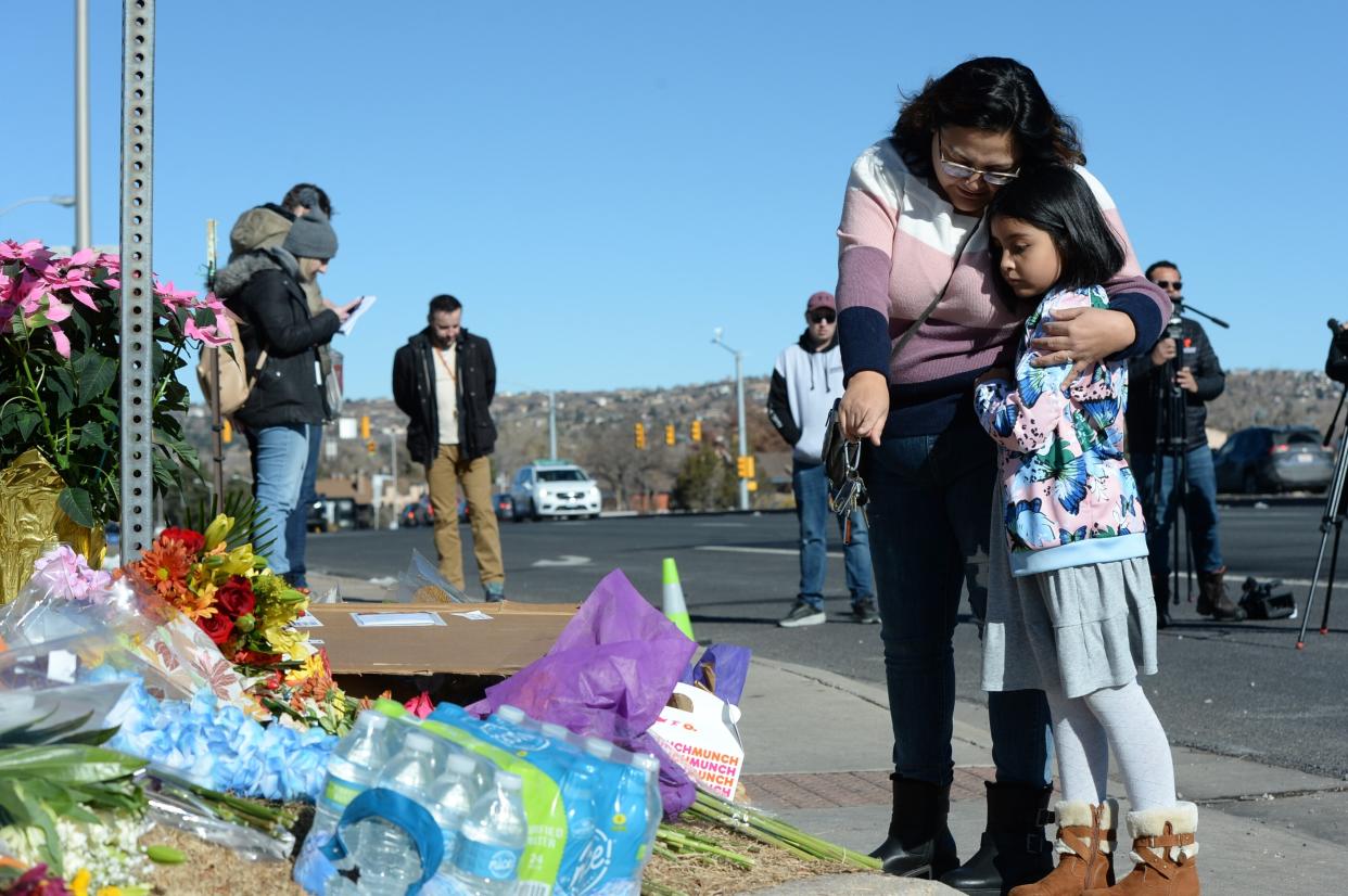 Crystal and Ella Mondragon place flowers at a makeshift memorial near a gay nightclub in Colorado Springs, Colo., Sunday, Nov. 20, 2022 where a shooting occurred late Saturday night. (AP PhotoGeneva Heffernan)