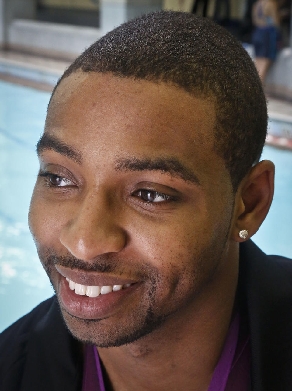 This May 17, 2013 photo shows Olympic gold medalist swimmer Cullen Jones posing poolside after giving swimming lesson's to students at Harlem's P.S. 125 in New York. Jones is ambassador for the 5th Annual USA Swimming Foundation's "Make a Splash Tour," a program to provide free swimming lessons, water safety education and awareness at city pools. (AP Photo/Bebeto Matthews)