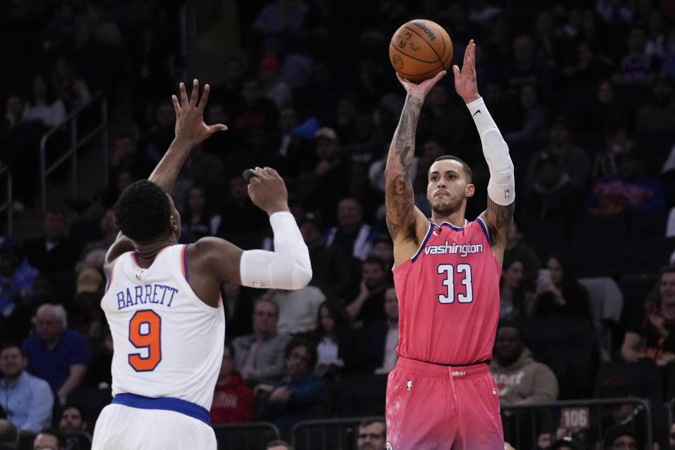Washington Wizards forward Kyle Kuzma (33) shoots a 3-point basket past New York Knicks guard RJ Barrett (9) during the second half of an NBA basketball game Wednesday, Jan. 18, 2023, at Madison Square Garden in New York. The Wizards won 116-105. (AP Photo/Mary Altaffer)