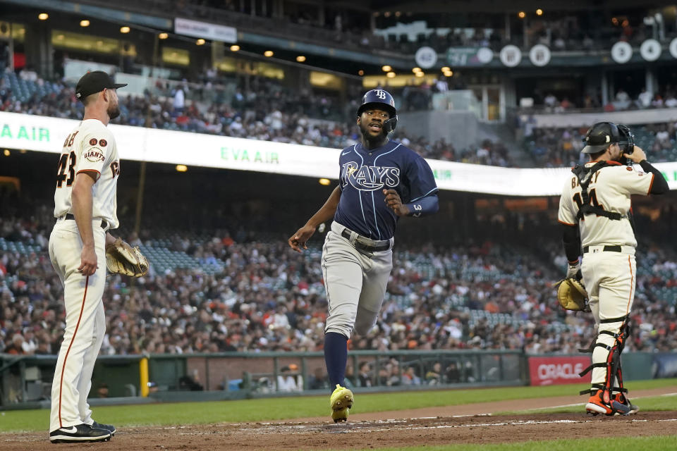 Tampa Bay Rays' Osleivis Basabe, middle, scores between San Francisco Giants pitcher Tristan Beck, left, and catcher Patrick Bailey during the fourth inning of a baseball game in San Francisco, Monday, Aug. 14, 2023. (AP Photo/Jeff Chiu)