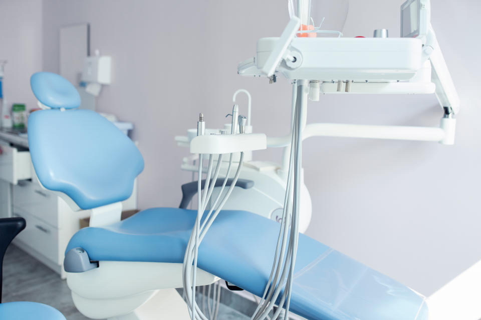 A modern, empty dental clinic with a dental chair and medical equipment. No people are present in the image