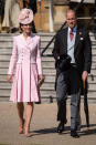 The Duke and Duchess of Cambridge at a Buckingham Palace garden party. Kate wore a pink Alexander McQueen coat dress with a matching hat by Juliette Botterill, her Gianvito Rossi praline pumps and her Loeffler Randall clutch. She accessorised with Princess Diana’s Collingwood pearl earrings. [Photo: PA]