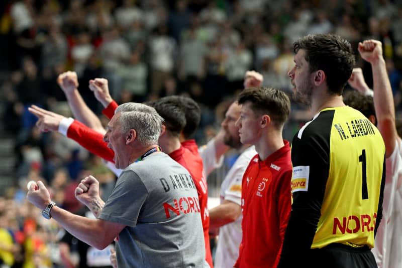 Denmark's coach Nikolaj Jacobsen (L) cheers during the 2024 EHF European Men's Handball semi-finals match between Denmark and Germany at Lanxess Arena. Federico Gambarini/dpa