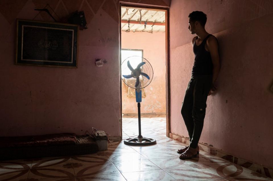 Mahmoud, 18, stands motionless in the humidity of his family home in Beit Lahia (Paddy Dowling)