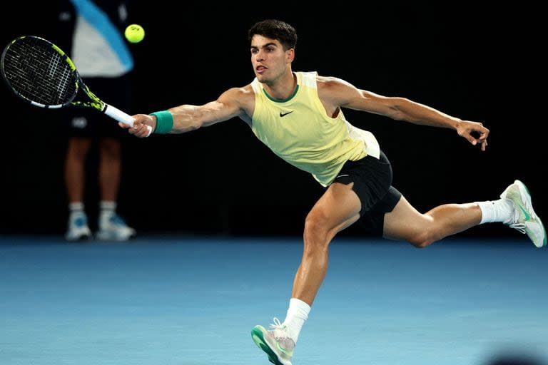 Con una camiseta sin mangas, como usaba Rafael Nadal, el español Carlos Alcaraz devuelve la pelota, durante el partido que le ganó al francés Richard Gasquet, por la primera rueda del Abierto de Australia 2024