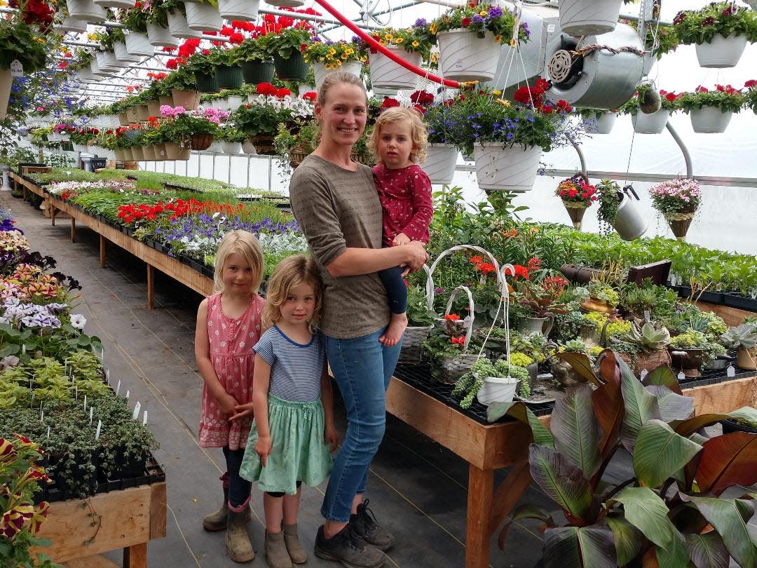 Becky Zimmerman in her greenhouse at The Home Place Nursery with her children, from left, Alice, 5; Abigail, 4; and Olivia, 2.