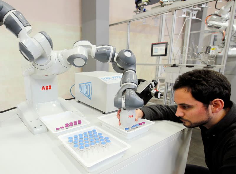 FILE PHOTO: Engineer Trilla of ABB adjusts an arm of a YuMi - IRB14000 robot in Baden