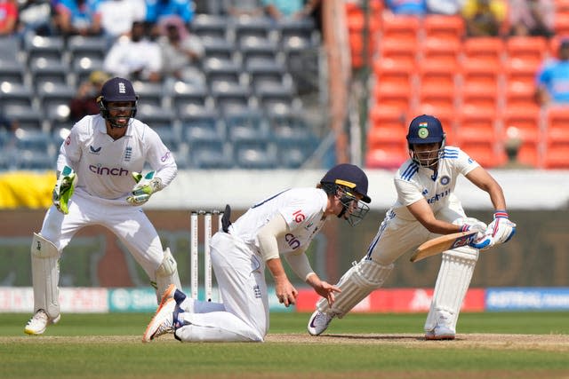 Ollie Pope, centre, takes a shot to remove Shubman Gill, right