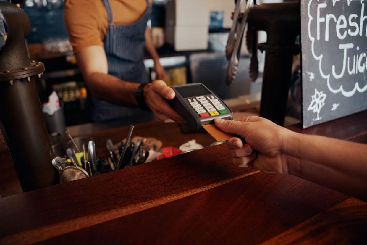 Close up of card payment between customer and bartender in cafe