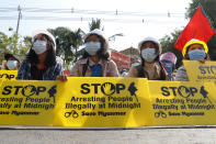 Mandalay University graduates hold posters that say "Stop Arresting People illegally at midnight" "Save Myanmar" during an anti-coup protest in Mandalay, Myanmar, Sunday, Feb. 14, 2021. Daily mass street demonstrations in Myanmar are on their second week, with neither protesters nor the military government they seek to unseat showing any signs of backing down from confrontations. (AP Photo)