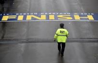 A Boston police officer walks towards the finish line before the start of the 119th running of the Boston Marathon in Boston, Massachusetts April 20, 2015. REUTERS/Gretchen Ertl