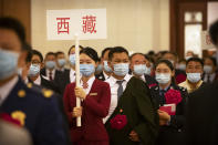 Attendees from Tibet wearing face masks arrive for an event to honor some of those involved in China's fight against COVID-19 at the Great Hall of the People in Beijing, Tuesday, Sept. 8, 2020. Chinese leader Xi Jinping is praising China's role in battling the global coronavirus pandemic and expressing support for the U.N.'s World Health Organization, in a repudiation of U.S. criticism and a bid to rally domestic support for Communist Party leadership. (AP Photo/Mark Schiefelbein)