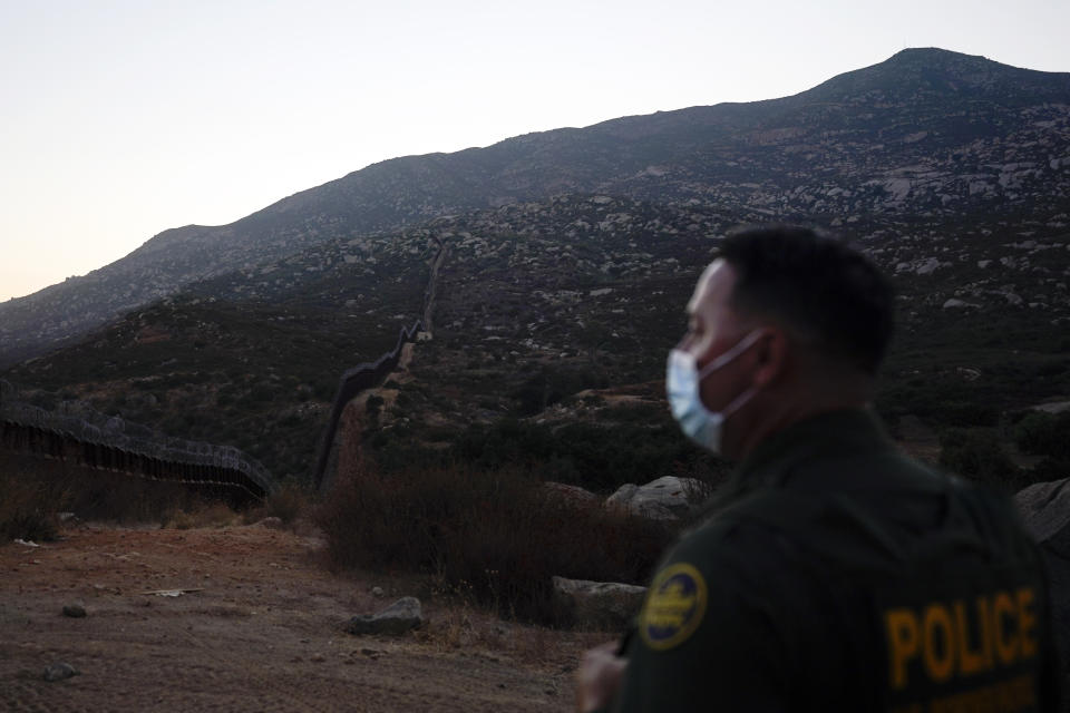 El agente de la Patrulla Fronteriza Justin Castrejón observa un sector escarpado de la frontera entre Estados Unidos y México cerca de Tecate, California, el 24 de septiembre del 2020. (AP Photo/Gregory Bull)